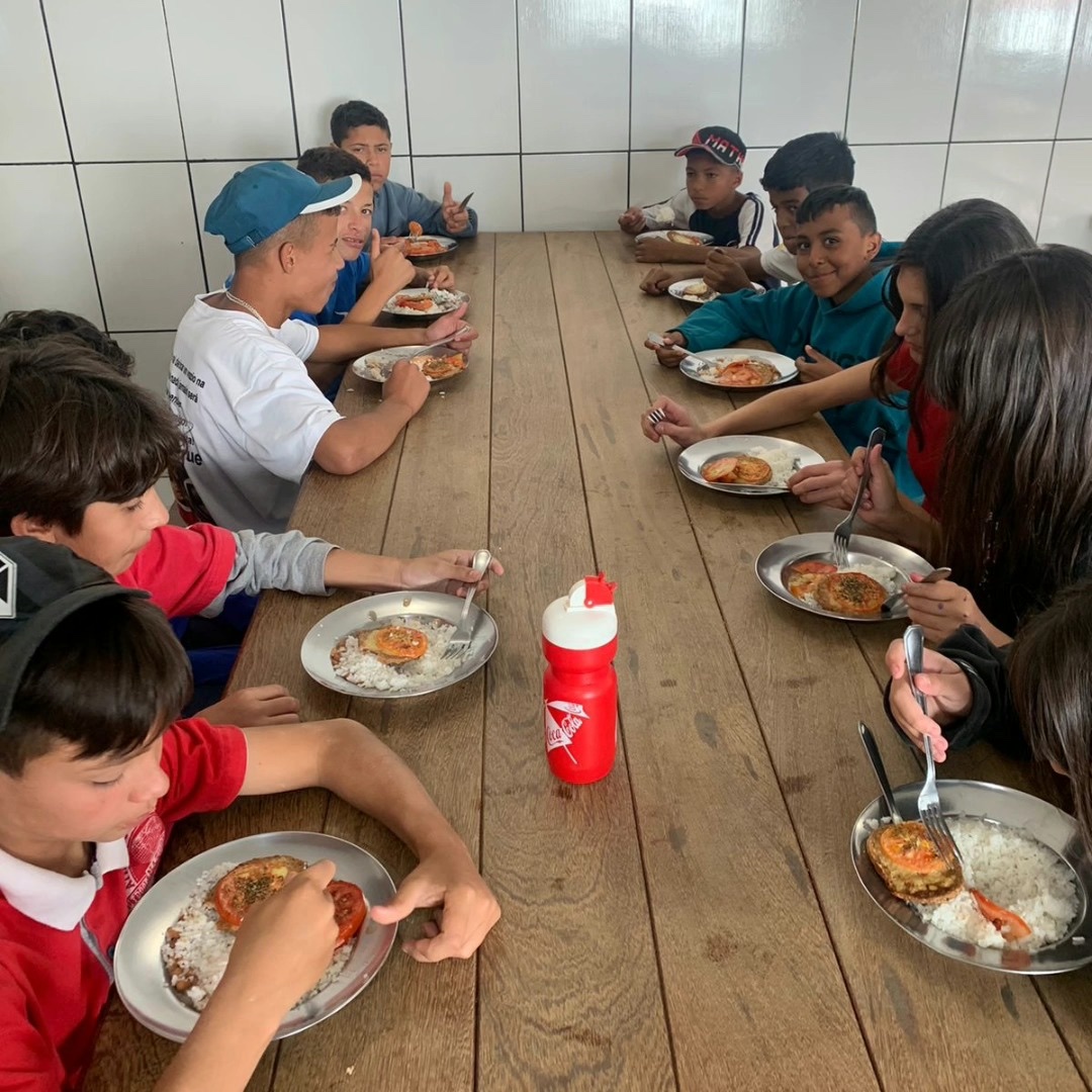 Crianças e adolescentes da POC compartilhando uma refeição